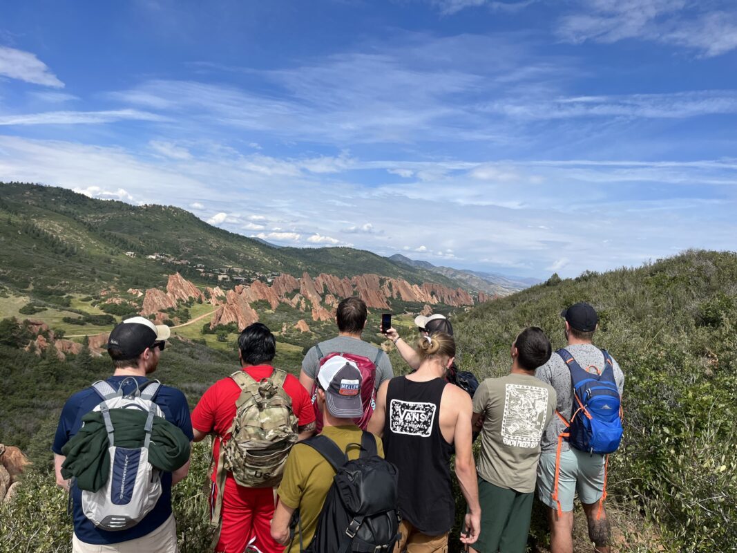 A group of Valiant men overlooking the red rock spires of Roxborough on a program hike