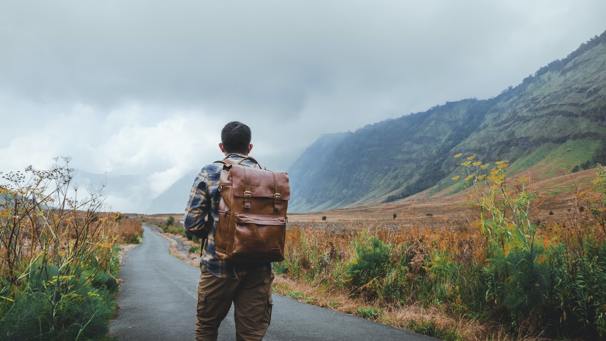 man walking on the road on a journey