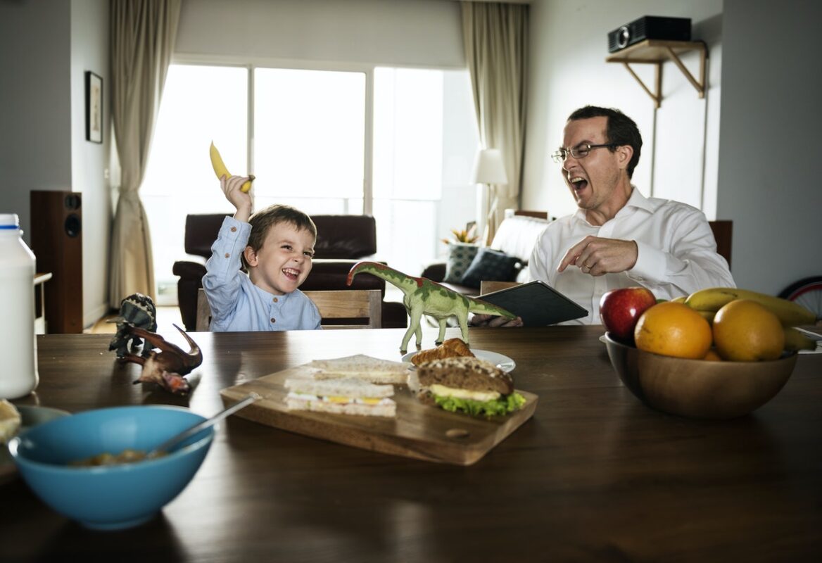 Father and son having fun at the breakfast table