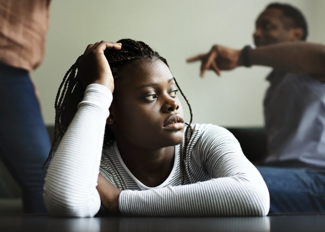 Daughter sitting sadly while her parents are fighting