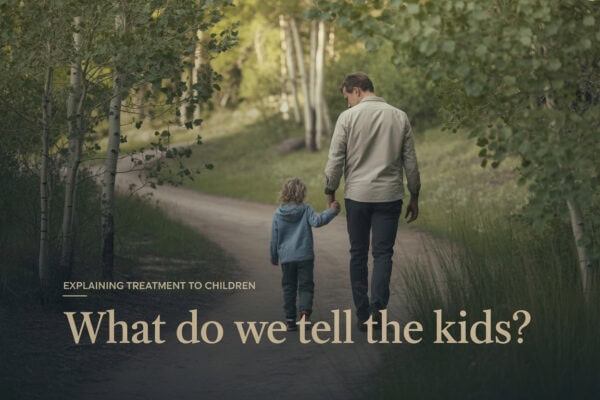 Father and child walking outdoors in nature, discussing treatment and recovery.